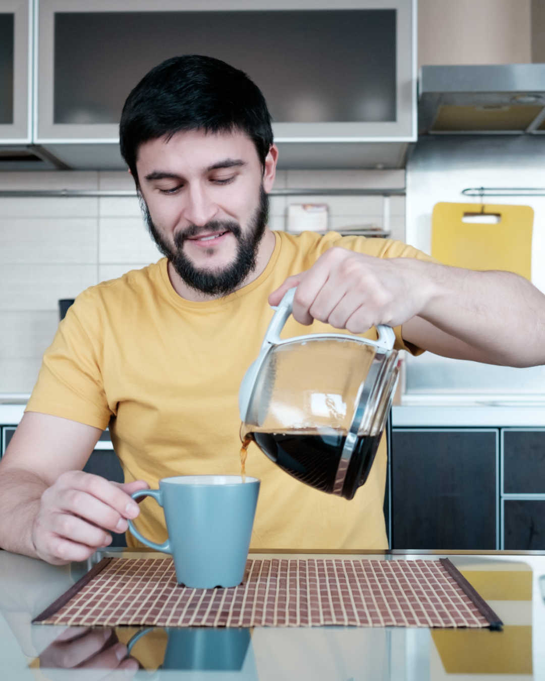 man pouring coffee in kitchen