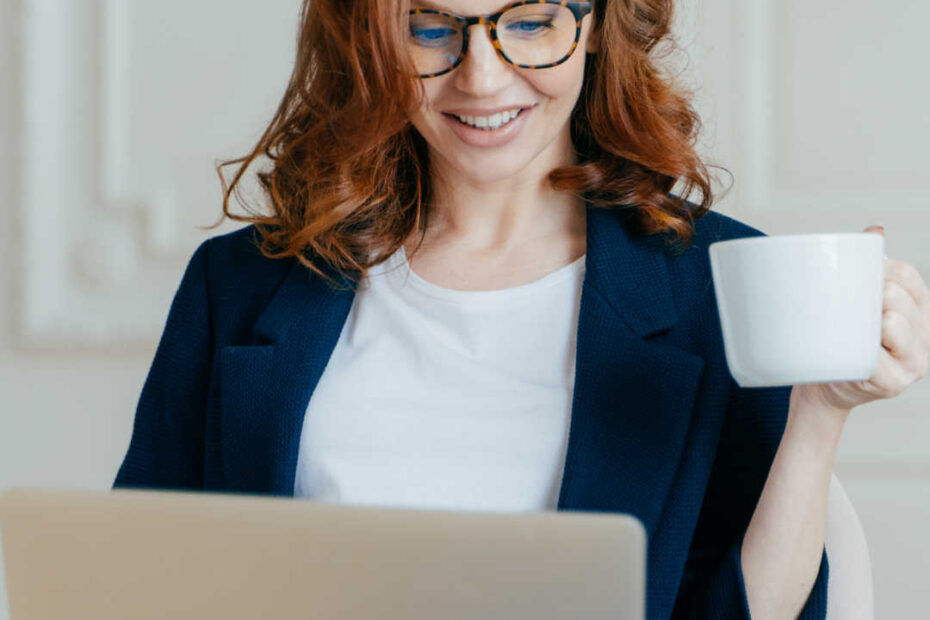 woman reading laptop with coffee