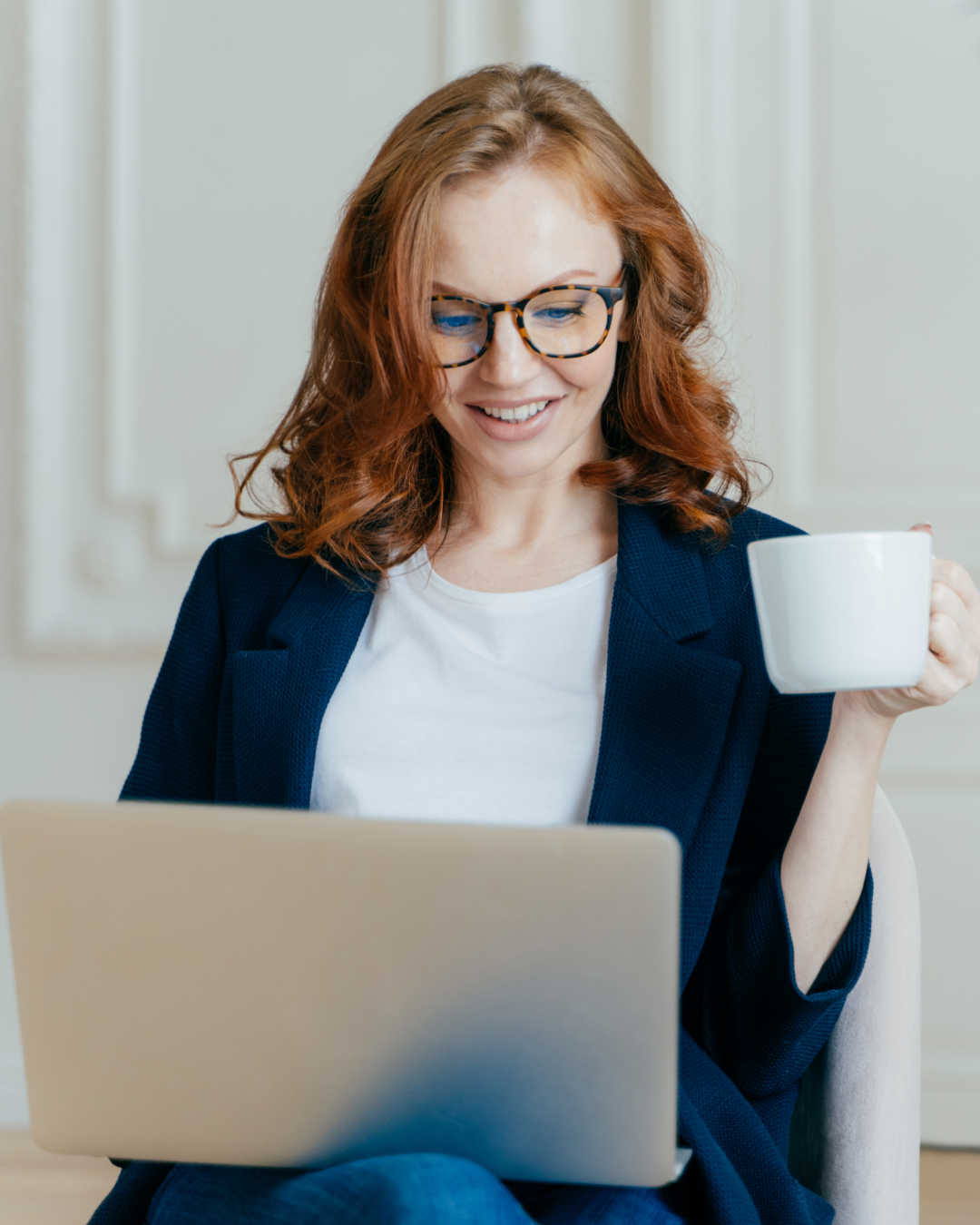 woman reading laptop with coffee