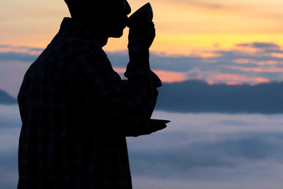 man in silhouette drinking coffee