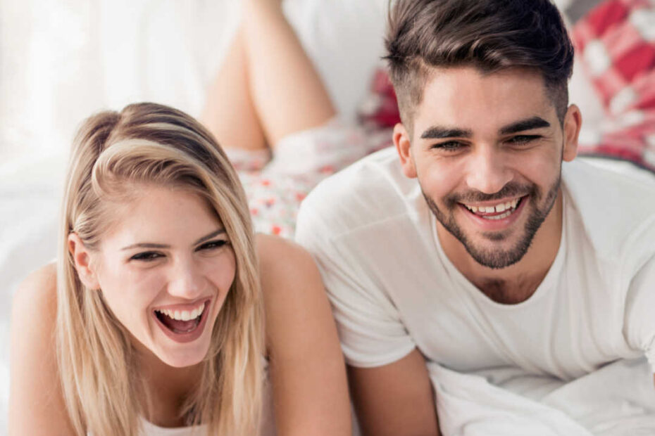 man and woman in bed with coffee