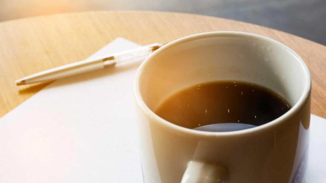 ceramic coffee mug with black coffee on table, soft light