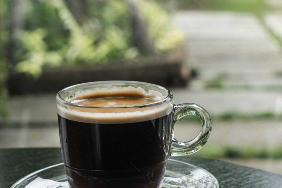 black coffee in clear cup on outdoor table