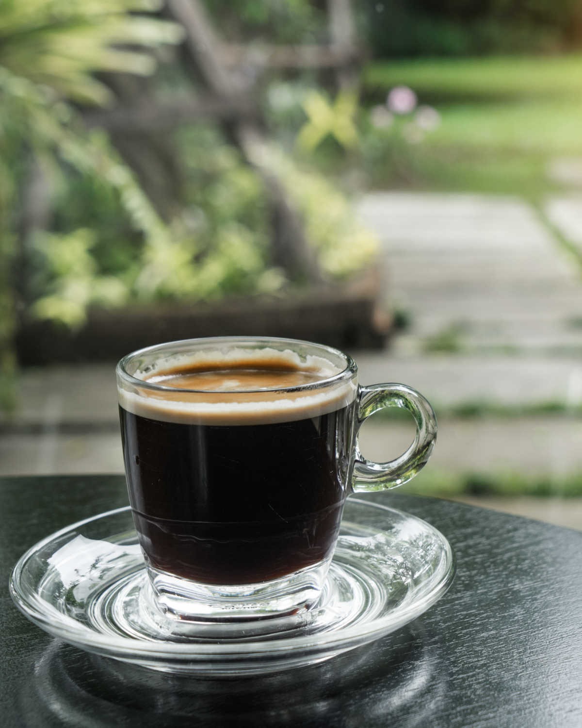 black coffee in clear cup on outdoor table