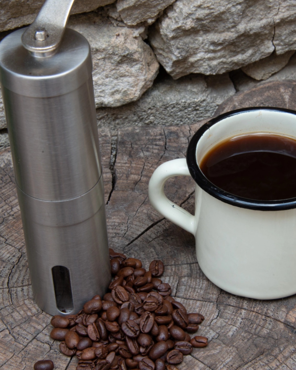 black coffee in mug with beans and grinder