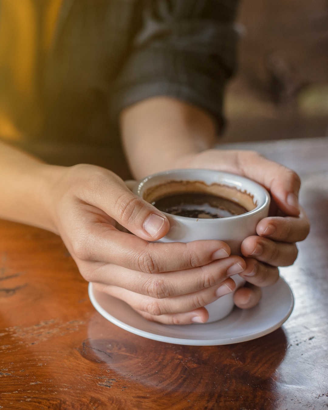 hands holding cup of coffee